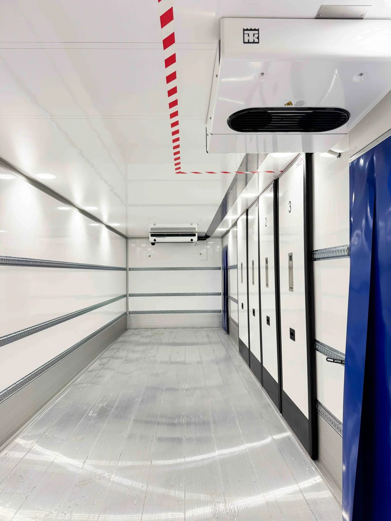 Interior of a refrigerated "FRC" trailer featuring a Frigoblock cooling unit mounted on the ceiling. The space includes blue thermal curtains, numbered internal partition doors (1, 2, 3) for multi-temperature zones, and a textured metal floor.